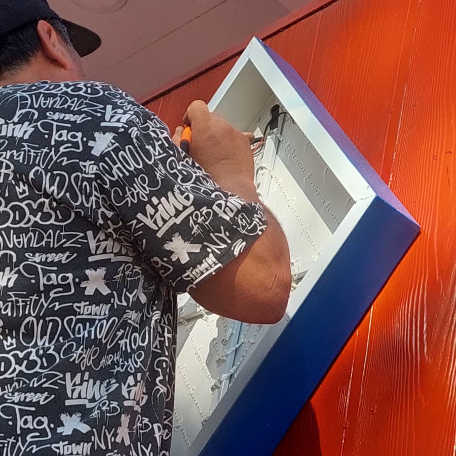 Fabricación de caja de luz LED con marco azul en el taller de Letreros Pizarro